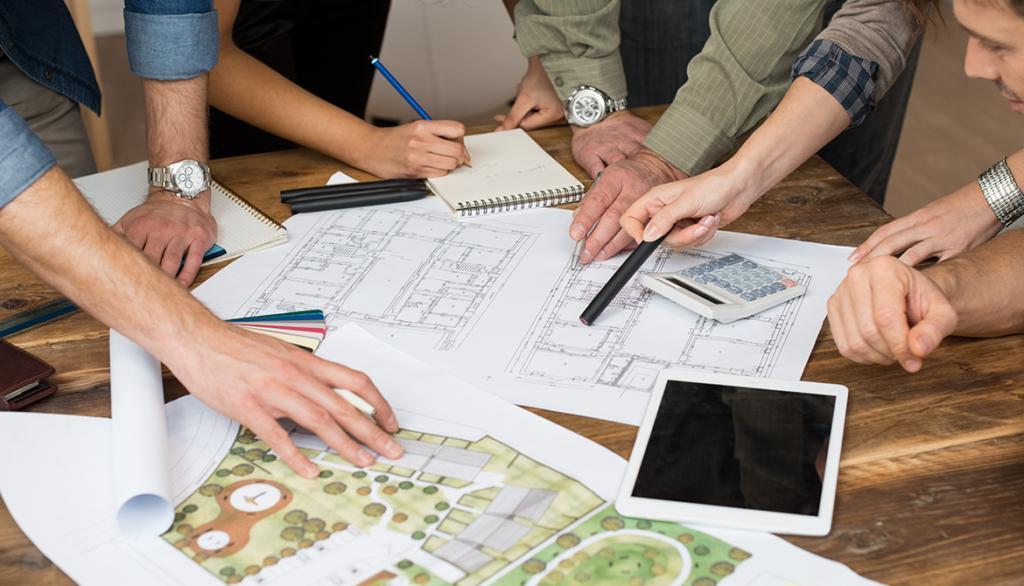 Équipe de jardiniers et architectes discutant des plans