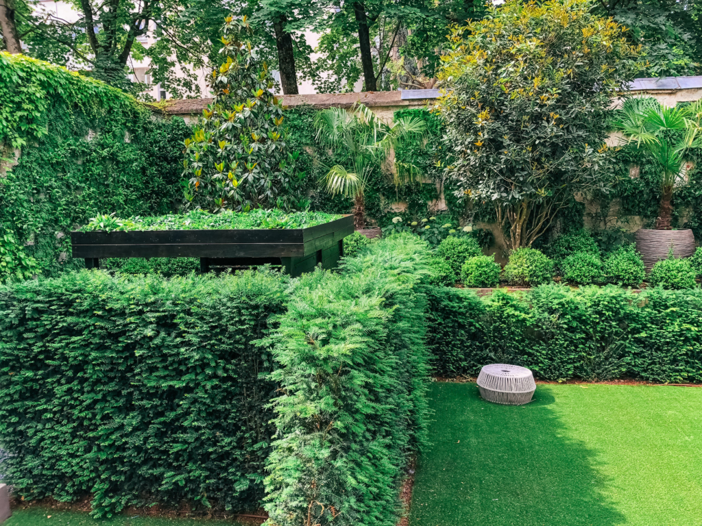 Mur végétal de luxe intégré dans un jardin structuré avec végétation dense.