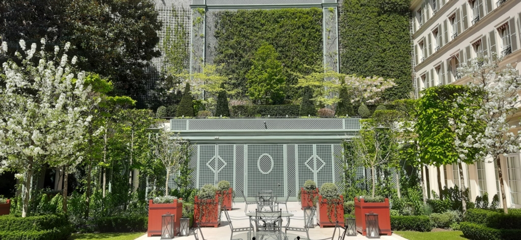 Terrasse de restaurant au cœur du Bristol à Paris, entourée d’un jardin paysager