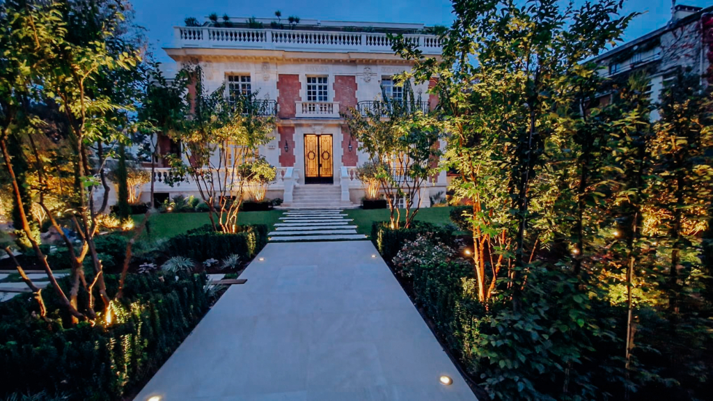 Aménagement paysager de château réalisé par un paysagiste de demeure de prestige, avec allée élégante, éclairage architectural et jardin structuré.