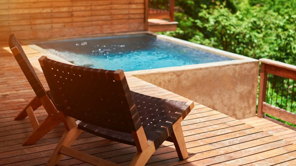 Terrasse en bois avec mobilier extérieur et bassin, illustrant le choix de matériaux durables et esthétiques pour un aménagement paysager.