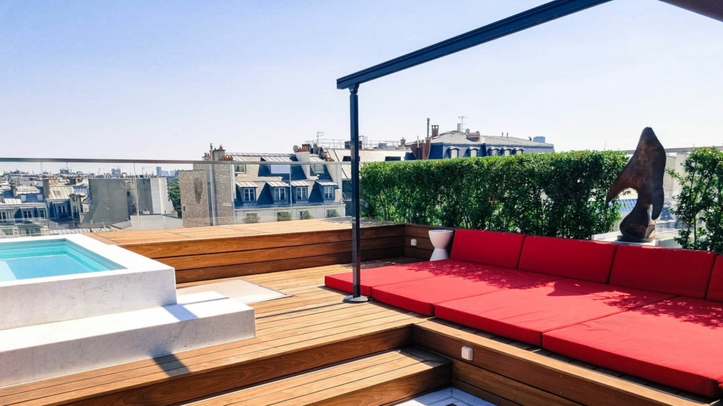 Zone de détente paysagée sur terrasse avec assises confortables, bassin et vue urbaine, pensée pour la contemplation et le bien-être.