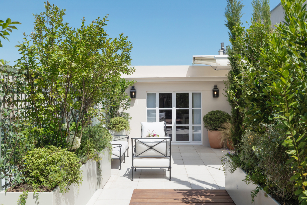 Terrasse végétalisée de la Suite Eden au Bristol à Paris, aménagement paysager hôtelier haut de gamme avec mobilier élégant et plantations structurées.