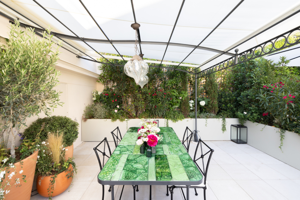 Pergola de restaurant au Bristol à Paris avec table dressée et végétation luxuriante