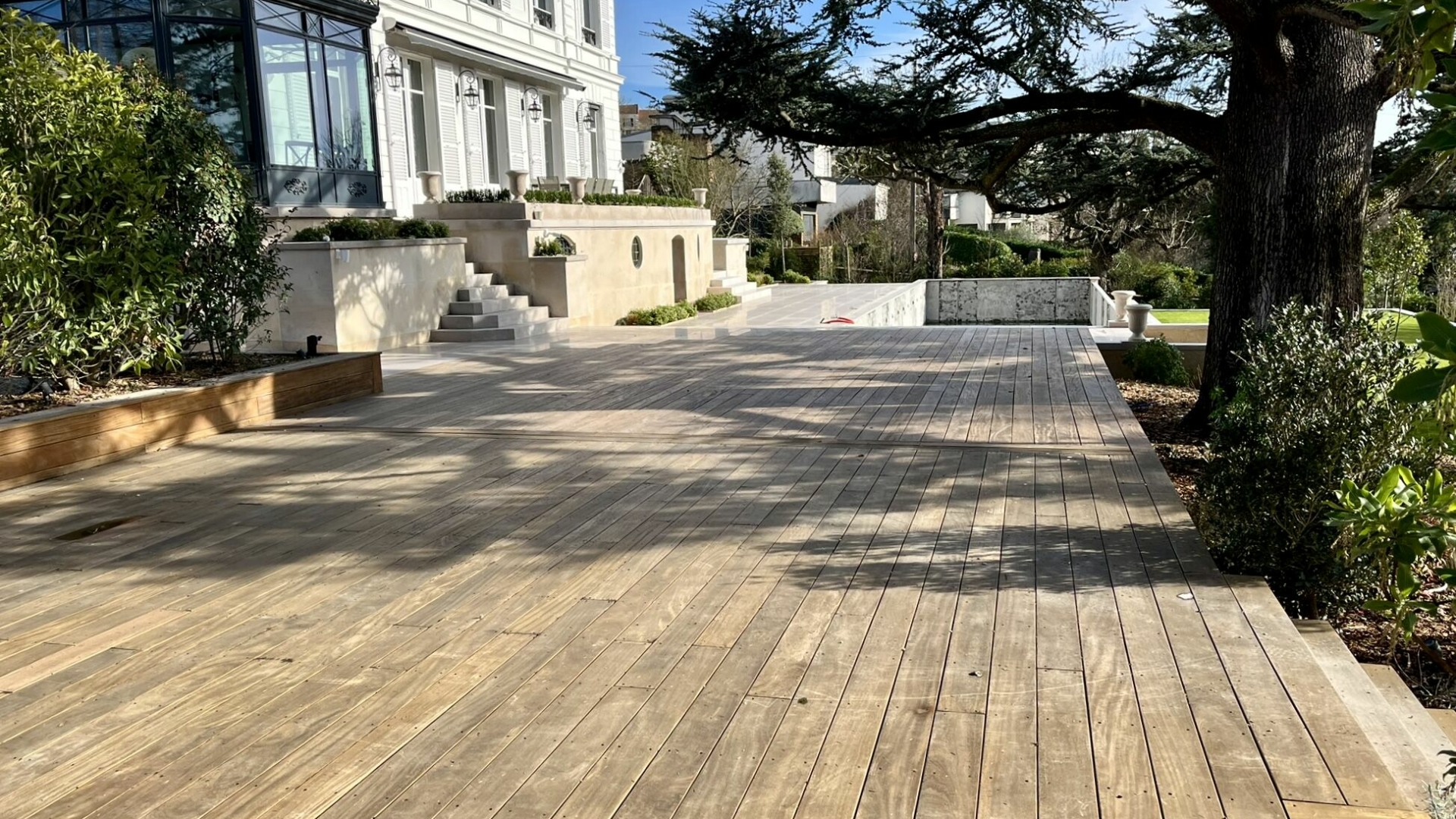 Terrasse en bois neuve avec piscine et demeure du Val-d'Oise, avant installation du mobilier