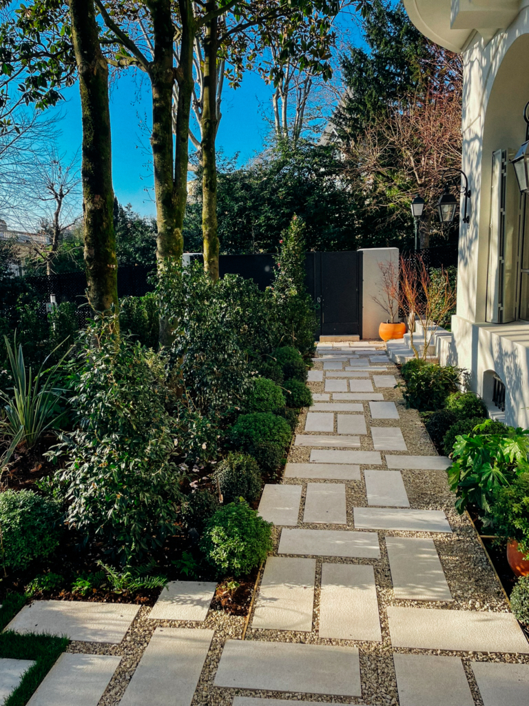 Allée de jardin contemporain à Paris avec pas japonais, végétation structurée et aménagement paysager haut de gamme