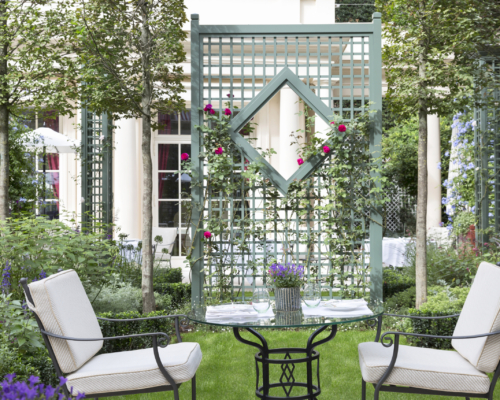Terrasse événementielle d’un palace parisien haut de gamme avec jardin raffiné, mobilier élégant et aménagement paysager de prestige.