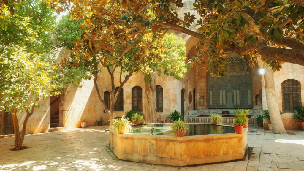 cour intérieure Cour intérieure méditerranéenne avec fontaine centrale, arbres ombragés et architecture en pierre naturelle élégante
