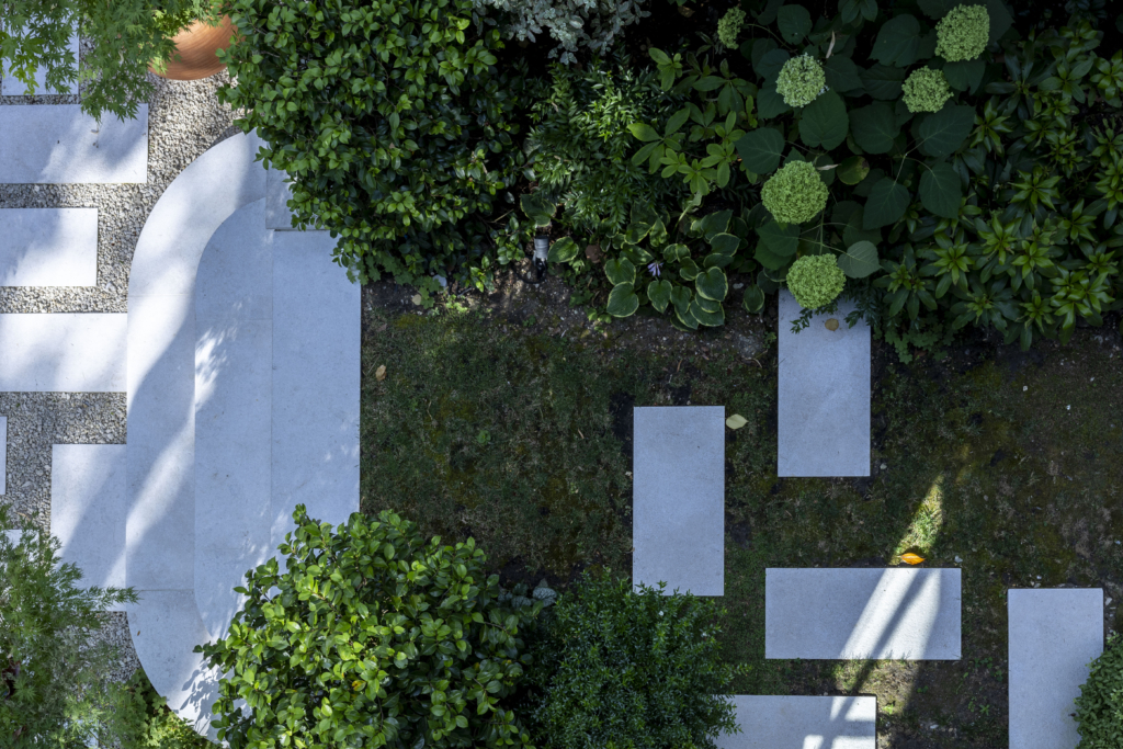 Jardin d'une résidence à Paris. Réalisation par le paysagiste Le Monde des Jardins. 10 juillet 2026. © Laurent Guichardon. Vue aérienne d'un jardin à Paris avec pas japonais en pierre, gravier et massifs d'hortensias